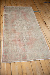 Angled view of a distressed Oushak runner highlighting its time-softened dusty rose and silver tones.