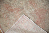 Folded corner of a vintage Oushak runner showing the hand-knotted foundation and worn pile.