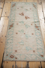 Vintage Distressed Oushak runner showing faded mint green and copper geometric border.