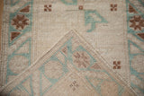 Distressed vintage Oushak rug corner, showing hand-knotted foundation and worn cream, copper, mint pile.