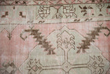 Distressed Oushak rug texture highlighting dusty pink, oxidized silver, and coffee brown serrated leaf motifs.