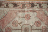 Distressed texture of vintage Turkish Oushak runner with dusty rose and ivory floral motifs.
