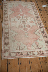 Distressed Oushak runner side, showing textured dusty rose pile and chocolate brown border.