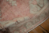 Distressed texture of the vintage Oushak rug runner's low pile and secured edge.