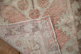 Distressed Oushak pile texture with rose, ivory, green tones, and hand-knotted foundation.