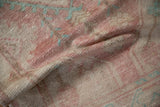 Soft, pliable texture of a distressed Oushak rug with faded raspberry and turquoise colors.