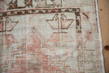 Geometric vine and floral motif in the main border of a distressed Turkish Oushak rug.