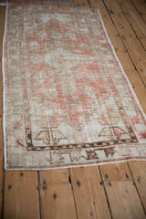 Angled view of a distressed Oushak runner showing its overall time-softened patina.