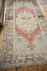 Angled view of a distressed Turkish Oushak runner with a soft, time-worn patina.