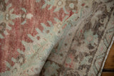 A soft fold in the distressed Oushak runner reveals its hand-knotted low pile texture.