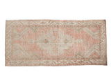 Distressed vintage Oushak runner with a geometric medallion in soft blush, beige, and pale sea foam green.