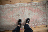 A person's perspective looking down at a blush and beige distressed Oushak rug for scale.