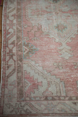 Close-up of the elongated serpent vine border on a distressed Oushak rug in soft blush and ivory.