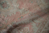 Softly folded vintage Oushak runner showing its low-pile texture in blush, ivory, and turquoise.