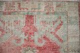 Close view of the distressed pile, showing knot heads in raspberry red and celadon green.