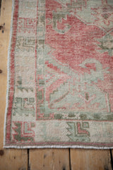 Low pile texture and side cord detail of the distressed vintage Oushak rug runner.