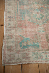 Distressed texture in faded pink and turquoise along the secured side of a vintage Oushak runner.