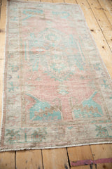 Full-length angled view of a vintage Oushak runner, highlighting its soft, faded pink and turquoise tones.