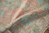 Folded corner of a vintage Oushak runner revealing its soft, low pile texture.