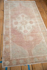 Distressed vintage Oushak runner; decorative soft dusty rose and ivory motifs.