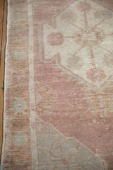 Distressed vintage Oushak rug runner's side edge with dusty rose and ivory pile.
