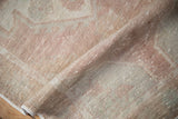 Distressed Oushak runner pile in dusty rose and ivory with faint foundation showing through.