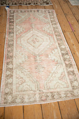Distressed Oushak rug with pale cherry red and cream hexagonal medallion.