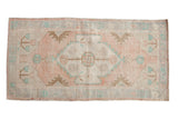Distressed Oushak runner rug featuring a dusty rose medallion, soft cream, and pale turquoise.