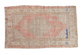 Vintage distressed Oushak rug with a raspberry pink medallion on an ivory field with cobalt accents.