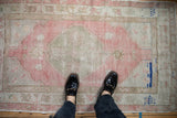 Softly colored vintage Oushak rug featuring a faded pink diamond medallion and unique cobalt blue accents.