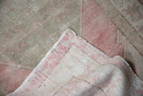 The hand-knotted back and secured side cord of a vintage distressed Turkish Oushak rug.