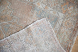 The hand-knotted reverse and low, time-softened pile of a distressed vintage Oushak rug.