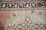 Distressed vintage Oushak runner with dusty cantaloupe, rose, and chocolate brown curvilinear motifs.