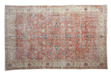 Distressed vintage Sparta carpet with blush field, ivory borders, and blue palmette vinery.