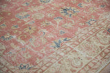 Worn dusty blush and beige floral pattern on vintage Sparta carpet with blue accents.