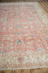 Distressed vintage Sparta carpet detail: worn floral palmettes in dusty blush, blue, ivory.