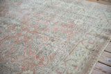Distressed Sparta rug with faded blush and silver floral design, showing worn pile texture.