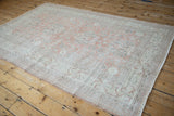 Distressed vintage Sparta rug with time-softened blush and silver floral vine patterns.
