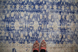 Distressed hand-knotted Oushak rug, showing cobalt blue and ivory pile worn to foundation.