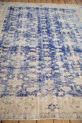 Distressed vintage Oushak carpet showing cobalt blue and worn ivory palette.