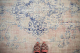 Distressed vintage Turkish Oushak rug, worn blue rococo motifs on faded rose and ivory.
