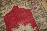 Distressed Oushak rug with cherry red field, stepped ivory design, and muted border.