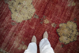 Vintage Kars carpet close-up: short pile with abrashed cherry red and dusty gold ribboned patterns.