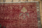 Heavily abrashed cherry red field with gold finial and oxidized silver border.