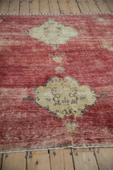 Rich cherry red abrash on a Kars carpet's field, revealing dusty gold medallion and finial details.