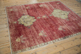 Corner of vintage Kars square carpet with cherry red field, machine-finished edge, and gold motif.