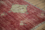 Vintage Kars carpet's abrashed cherry red field, revealing ribboned design and short pile.