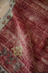 Abrashed cherry and raspberry red field of a vintage Kars rug, showing ribboned elements.