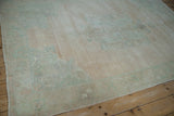 Time-softened tones of pale green and blush across the evenly worn pile of a vintage Oushak.