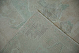 Close-up of the vintage Oushak carpet's corner, showing the hand-knotted reverse and evenly worn pile.